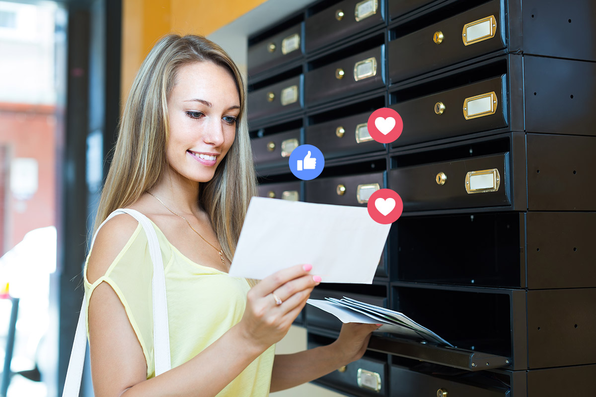 Lady checking mail and reading direct mail postcard with social engagement call to action - hearts and like icons float above the postcard